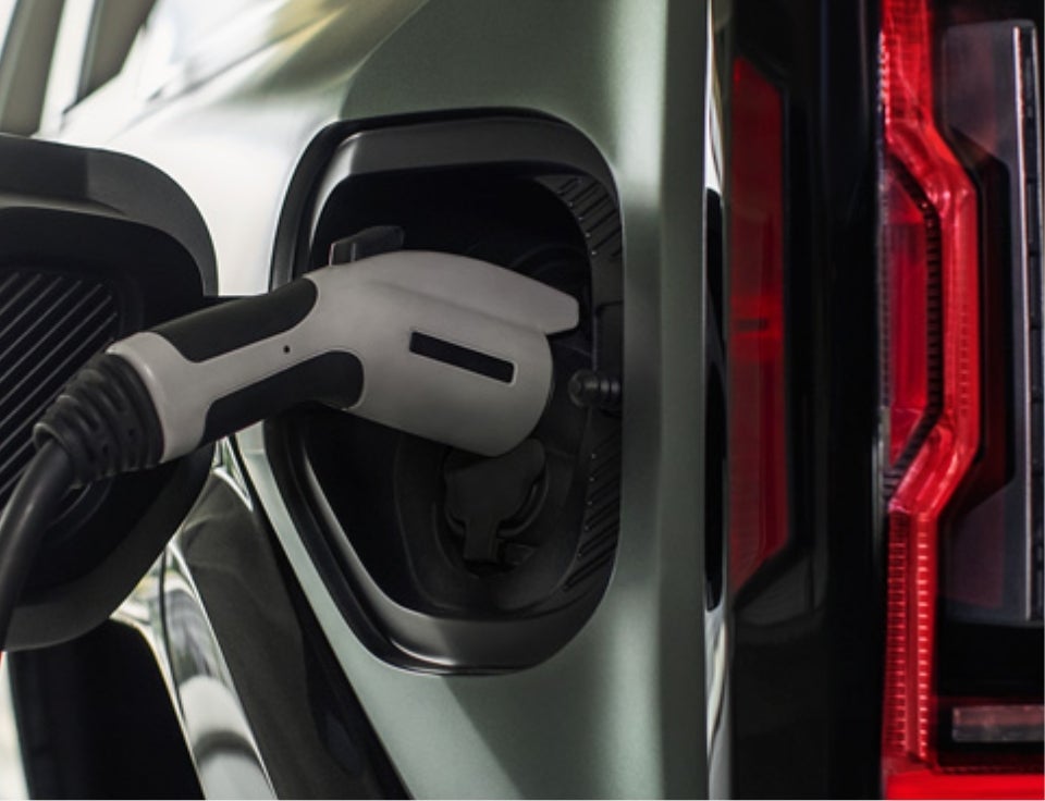 Close up of charging port with charger plugged in on a GMC Hummer EV SUV - Watsonville GMC in Watsonville CA